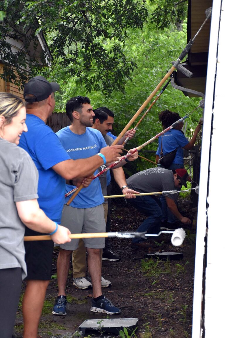 Volunteers using paint rollers to revitalize a home during a 6 Stones Community Powered Revitalization project