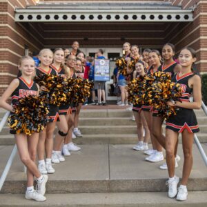 Cheerleaders welcome families to Operation Back 2 School.