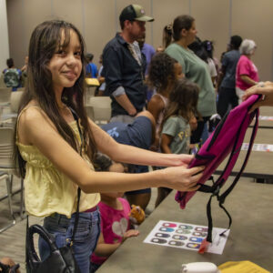 Student receives a backpack at Operation Back 2 School.
