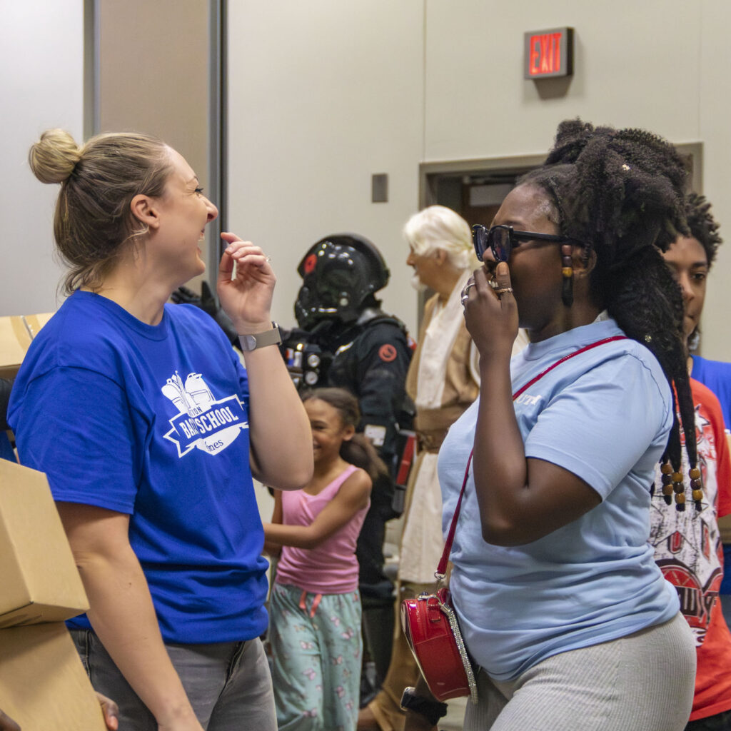 Volunteer talks with a family during Operation Back 2 School.