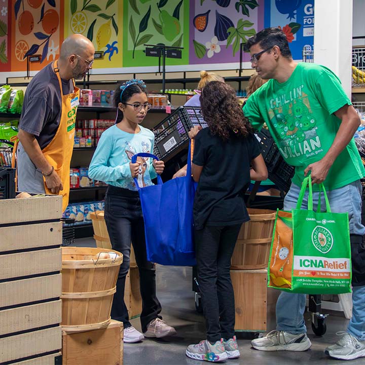 Volunteers help families with groceries through 6 Stones Rescue support.