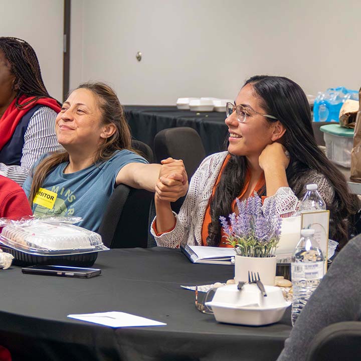 Women sit together in a 6 Stones mentoring or support gathering.