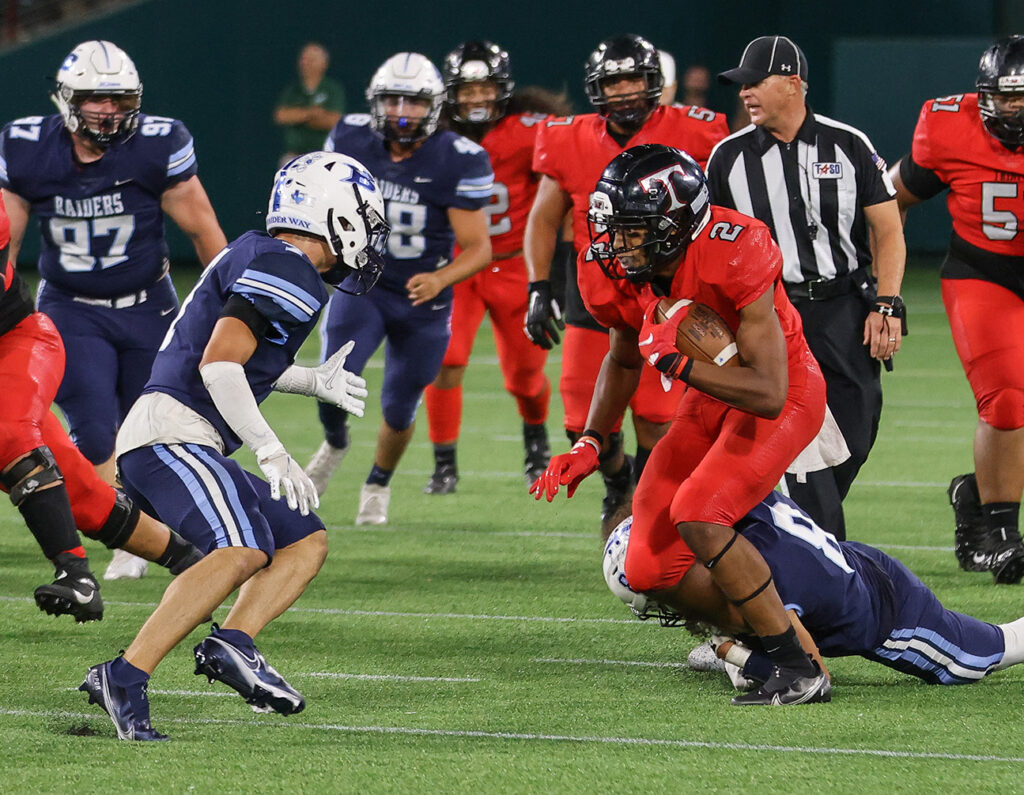 Trinity and L.D. Bell football players compete during the Black & Blue rivalry game.